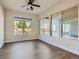 Bedroom with dark wood floors, ceiling fan, and multiple windows showcasing the backyard at 3008 Barrett Springs Ave, Henderson, NV 89044