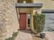 Close up shot of front entrance with a stone accent wall, red door, and desert landscaping at 3008 Barrett Springs Ave, Henderson, NV 89044