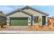 Charming single-story home with a green garage door, desert landscaping, and a brick-paved driveway at 3241 Walker River St, North Las Vegas, NV 89032