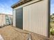 Exterior shot of beige shed featuring a dark gray sliding door, set against a gravel bed at 4009 Patterson Ave, Las Vegas, NV 89104