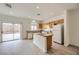 Well-lit kitchen featuring modern appliances, wood cabinets, an island, and sliding glass door to the backyard at 4045 Oliver Sagebrush Dr, Las Vegas, NV 89122