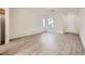 Spacious living room featuring modern wood floors, large windows, and easy access to the kitchen and entryway at 4045 Oliver Sagebrush Dr, Las Vegas, NV 89122