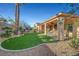 Landscaped backyard featuring artificial turf and a covered patio for outdoor entertaining at 4379 Bella Cascada St, Las Vegas, NV 89135