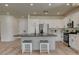 Modern kitchen boasts white cabinets, stainless steel appliances, and an island with bar stool seating at 4379 Bella Cascada St, Las Vegas, NV 89135