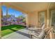 Covered patio with comfortable seating, palm trees, and views of the backyard at 4379 Bella Cascada St, Las Vegas, NV 89135