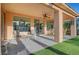 Covered patio with comfortable seating, ceiling fan, and views of the backyard at 4379 Bella Cascada St, Las Vegas, NV 89135