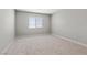 Neutral bedroom featuring soft carpet, a large window with blinds, and ample natural light at 4405 Pioche Ave, North Las Vegas, NV 89032