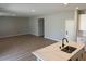 Bright kitchen with white cabinets, an island with quartz countertop, and wood-look floors extending into the living area at 4405 Pioche Ave, North Las Vegas, NV 89032