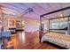 Open bedroom with modern fixtures, a fireplace, wood flooring, exposed ceiling and a writing desk at 5096 Thunder River Cir, Las Vegas, NV 89148