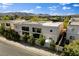 Striking aerial view of the property showcasing its contemporary architecture and lush landscaping against a mountain backdrop at 5096 Thunder River Cir, Las Vegas, NV 89148
