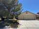 Inviting home exterior with a spacious driveway leading to a two-car garage and mature landscaping at 5121 Burr Oak Dr, Las Vegas, NV 89130