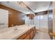 Traditional bathroom with a dual sink vanity, tiled countertop, shower, and a large mirror at 5405 Ireland St, Las Vegas, NV 89149