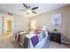 Comfortable bedroom featuring a ceiling fan, warm-toned walls, carpet, and a doorway to a bathroom at 5710 E Tropicana Ave # 2122, Las Vegas, NV 89122