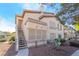 Charming condo with stucco exterior and stairs leading to the entrance, set in a desert landscape at 5710 E Tropicana Ave # 2122, Las Vegas, NV 89122