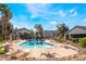 Beautiful community pool with tables and chairs surrounded by green landscaping and palm trees at 5710 E Tropicana Ave # 2122, Las Vegas, NV 89122