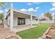 Expansive backyard with artificial turf, a covered patio, and landscaped features at 6437 Burgundy Way, Las Vegas, NV 89107
