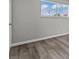 Bright bedroom with neutral paint, gray plank flooring, and view of the backyard through the window at 6437 Burgundy Way, Las Vegas, NV 89107
