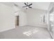 Spacious bedroom with large windows, ceiling fan, sliding glass door, and walk-in closet at 6961 Emerald Springs Ln, Las Vegas, NV 89113