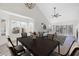 Bright dining area adjacent to living area with large windows and vaulted ceiling at 6961 Emerald Springs Ln, Las Vegas, NV 89113