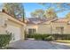 Inviting home exterior featuring a red tile roof, green landscaping, and an attached two-car garage at 6961 Emerald Springs Ln, Las Vegas, NV 89113