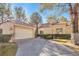 Charming single-story home with a well-manicured lawn, mature trees, and a two-car garage at 6961 Emerald Springs Ln, Las Vegas, NV 89113