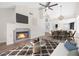 Bright, open living space with fireplace, vaulted ceilings, ceiling fan, and adjacent dining area at 6961 Emerald Springs Ln, Las Vegas, NV 89113