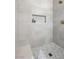 A tiled shower with a built-in niche and a pebble floor at 6961 Emerald Springs Ln, Las Vegas, NV 89113
