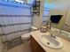 Well-lit bathroom with a vanity, mirror, and shower with striped curtains at 7109 Rancho De Taos, Las Vegas, NV 89130