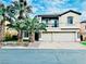 Two-story home with a balcony, two-car garage, palm trees, and stone accents at 7109 Rancho De Taos, Las Vegas, NV 89130