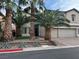 Two-story home with a three car garage, manicured landscaping, and mature palm trees at 7109 Rancho De Taos, Las Vegas, NV 89130
