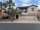 Two-story home with a three car garage, manicured landscaping, and mature palm trees at 7109 Rancho De Taos, Las Vegas, NV 89130