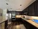 Well-lit kitchen featuring granite countertops, dark cabinetry, stainless steel appliances, and wood laminate flooring at 7109 Rancho De Taos, Las Vegas, NV 89130