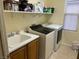 Functional laundry room with modern washer and dryer, a sink, and ample storage space at 7109 Rancho De Taos, Las Vegas, NV 89130