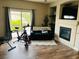 Inviting living room with a fireplace, mounted TV, exercise bike and sliding glass door at 7109 Rancho De Taos, Las Vegas, NV 89130