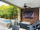 Charming outdoor patio featuring a lounge area with comfortable seating, a TV, ceiling fan, and beautiful landscaping at 7109 Rancho De Taos, Las Vegas, NV 89130