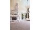 Spacious living room featuring a stone fireplace, tall ceilings, modern lighting, and floor to ceiling glass doors and windows at 72 Innisbrook Ave, Las Vegas, NV 89113
