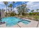 Backyard with a refreshing pool and spa, surrounded by lush greenery and palm trees at 72 Innisbrook Ave, Las Vegas, NV 89113