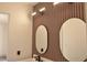 Contemporary bathroom with dual round mirrors, modern lighting, and slat wood accent wall at 7413 Red Eagle St, Las Vegas, NV 89131