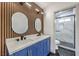 Modern bathroom featuring a double vanity, unique mirrors, and a stylish glass-enclosed shower at 7413 Red Eagle St, Las Vegas, NV 89131