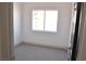 Clean, minimalist bedroom with neutral carpet, white walls and black trim door at 7413 Red Eagle St, Las Vegas, NV 89131