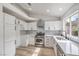 Beautiful kitchen showcasing stainless steel appliances, light hardwood floors and white cabinetry at 7413 Red Eagle St, Las Vegas, NV 89131