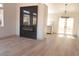 Bright living room featuring wood floors, black marble fireplace, and double doors to the patio at 7413 Red Eagle St, Las Vegas, NV 89131