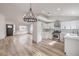 Open concept living room and kitchen featuring light hardwood floors and modern finishes throughout at 7413 Red Eagle St, Las Vegas, NV 89131