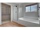 This bathroom features a tub, glass enclosed shower, and a glimpse into the walk-in closet at 9017 Wolf Dancer Ave, Las Vegas, NV 89143