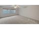 Spacious bedroom with neutral carpet, ceiling fan, and views of the landscaped backyard at 9017 Wolf Dancer Ave, Las Vegas, NV 89143
