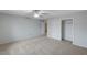 A large, carpeted bedroom with a ceiling fan and a closet with sliding doors at 9017 Wolf Dancer Ave, Las Vegas, NV 89143