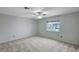 A carpeted bedroom featuring a ceiling fan, a window, and neutral walls at 9017 Wolf Dancer Ave, Las Vegas, NV 89143