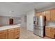 Bright kitchen features stainless steel appliances, wood cabinets and tile floors at 9017 Wolf Dancer Ave, Las Vegas, NV 89143