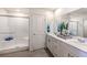 Sleek bathroom featuring double sinks, white cabinetry, and a glass-enclosed shower at 4755 Bluebird Cliffs Ave Dr # Lot 173, Las Vegas, NV 89141