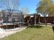 Backyard featuring mature trees, trampoline, and a pergola with seating at 1004 Windy Ferrell Ave, North Las Vegas, NV 89081